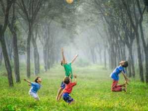 Kinder beim Ballspielen in der Natur