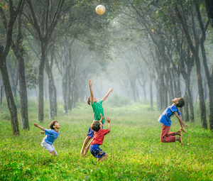 Kinder beim Ballspielen in der Natur
